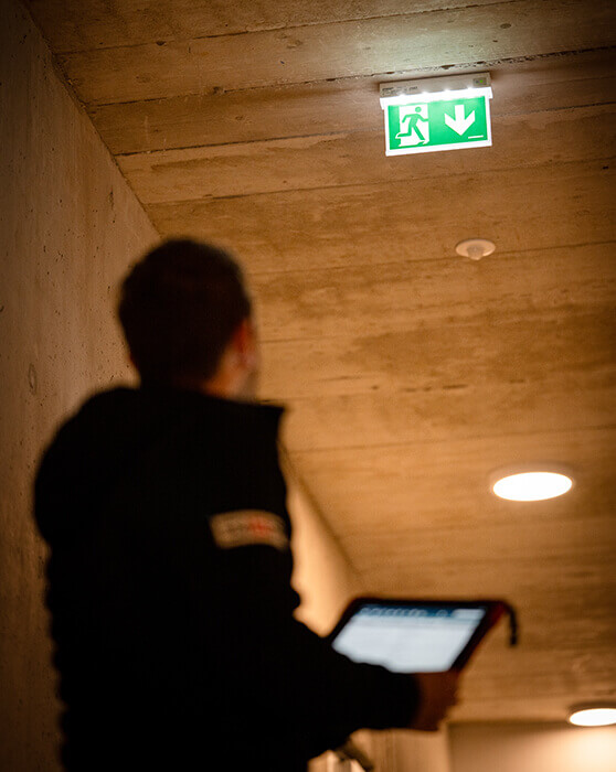 Mitarbeiter inspiziert Fluchtwegtafel